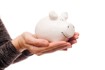 Woman hands are holding white porcelain pig, isolated on white background