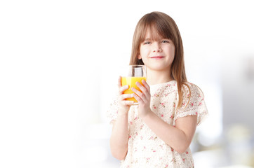 Cute girl drinking orange juice