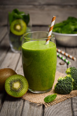 Healthy green smoothie and ingredients. Rustic background. Selective focus.