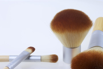 A set of bamboo brushes for applying makeup. Brushes for makeup: blush, eye shadow and correction. Of different sizes and diameters. Yellow and silver color on a white background.