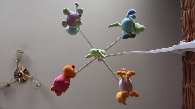 musical baby mobile with soft toys rotate above baby cot, bottom view