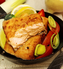 Salmon steak fried in frying pan.