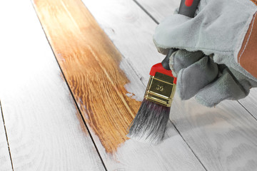 Hand Holding Brush Painting White Color on Wood