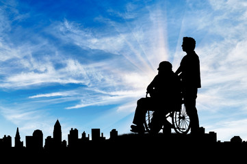 Fototapeta na wymiar Silhouette of man looking after disabled person