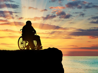 Obraz na płótnie Canvas Silhouette of disabled person in a wheelchair