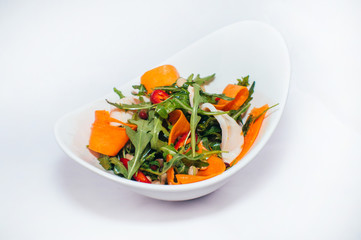 Fresh vegetable vegetarian salad with arugula and carrots on white