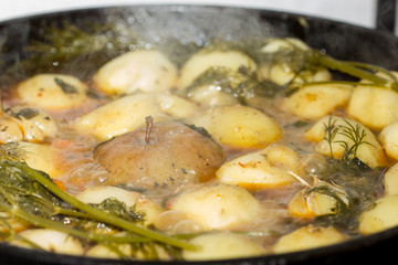 Meat with potatoes, apples and garlic  in a cauldron on fire, Uzbek cuisine.