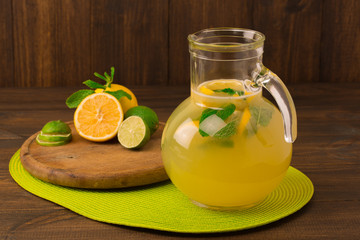 homemade lemonade with lime, mint in a mason jar on a wooden table