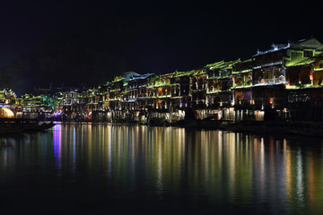 Fototapeta na wymiar View of illuminated riverside houses in Fenghuang