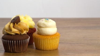 Three cupcakes on wooden board