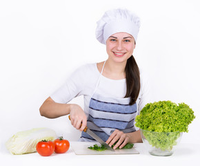 widely smiling girl chef cuts salad