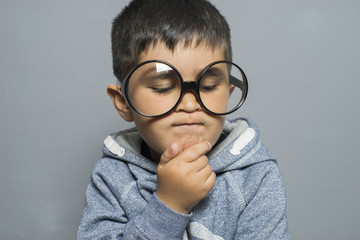 thinking, boy with big glasses very serious and thinking