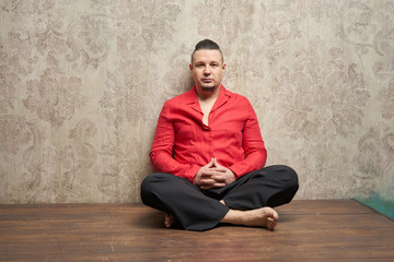 Fototapeta premium Portrait of a young man, in red shirt and black slacks, hairstyl