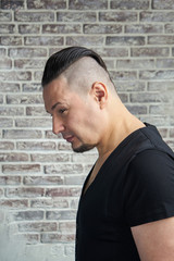 Fototapeta premium Close-up portrait of a young man, dressed in black T-shirt hairs