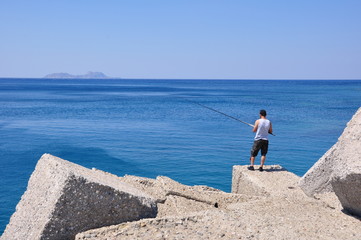 Fototapeta na wymiar Angler am Hafen von Agia Galini / Insel Kreta