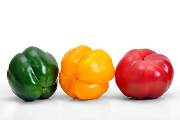 assorted fresh multicolored peppers on white background, positioned as horizontal traffic light