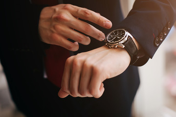 Closeup businessman looks at his watch - obrazy, fototapety, plakaty