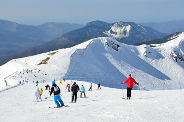 Fototapeta na wymiar Сочи, горнолыжный курорт Роза Хутор. Люди катаются на горных лыжах и сноубордах
