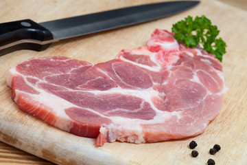 Schweinenackenkotelett auf einem Holzbrett