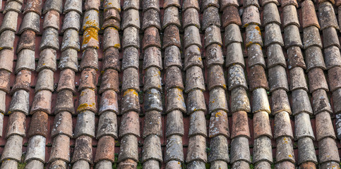 Old weathered red tile roof closeup photo. Background
