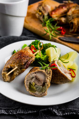 Pork rolls with cucumber and onion on plate