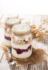 Tasty yoghurts with muesli, fresh berries and  jam.