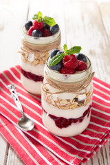 Tasty yoghurts with muesli, fresh berries and  jam.