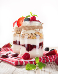Tasty yoghurts with muesli, fresh berries and  jam.