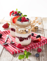Tasty yoghurts with muesli, fresh berries and  jam.