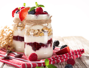 Tasty yoghurts with muesli, fresh berries and  jam.