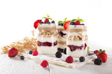 Tasty yoghurts with muesli, fresh berries and  jam.