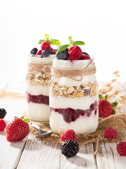 Tasty yoghurts with muesli, fresh berries and  jam.