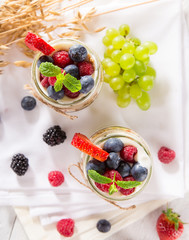 Tasty yoghurts with muesli, fresh berries and  jam.