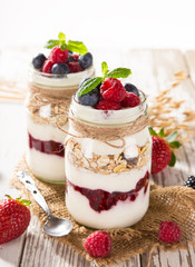 Tasty yoghurts with muesli, fresh berries and  jam.