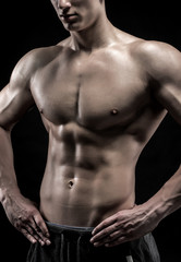 Fototapeta na wymiar Close-up of a power fitness man on black background