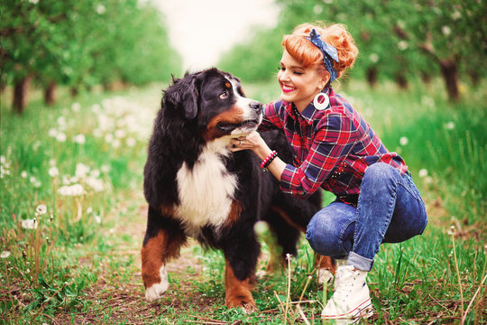 woman girl with dog bern in spring garden