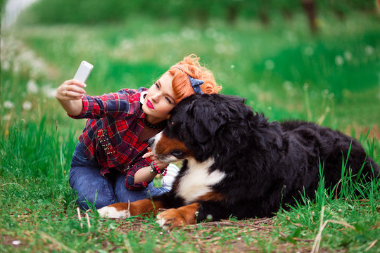 woman girl with dog bern in spring garden, selfy phone