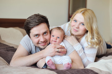 Fototapeta na wymiar Happy Young Attractive Family parents with Newborn Baby