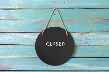 closed sign hanging on blue background