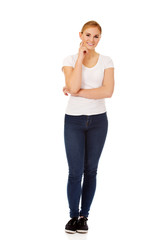 Fototapeta premium Young woman with folded hands and finger on cheek