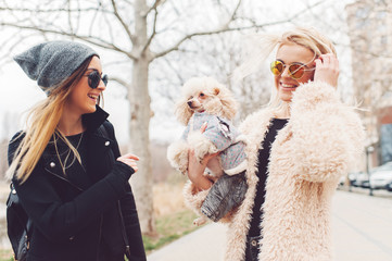 two young caucasian cute girls portrait with dog outdoor in park walking happy and smile all the way
