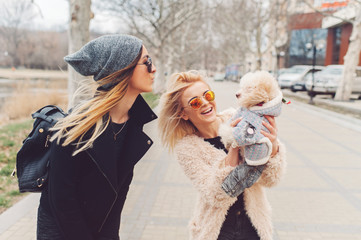 two young caucasian cute girls portrait with dog outdoor in park walking happy and smile all the way
