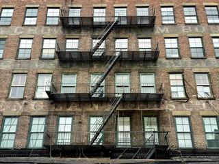 Fototapeta na wymiar Fire escape with windows on old urban building