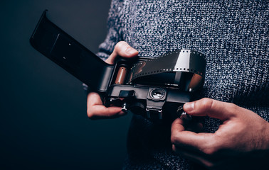 Photographer loading 35mm film in analog camera.How it works concept