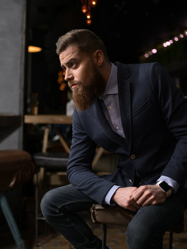 Cheerful bearded businessman is waiting in cafe