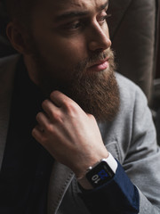 Pensive young man with beard is thinking