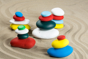 Cinq cairns faits de galets de différentes couleurs dans le sable,type jardin japonais