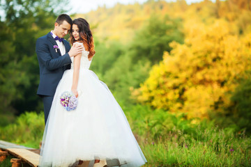Fototapeta na wymiar Elegant bride and groom posing together outdoors on a wedding da