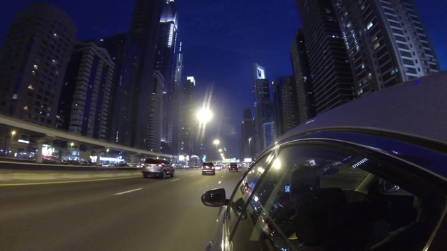 Dubai, modern urban busy city street front  view from car at night