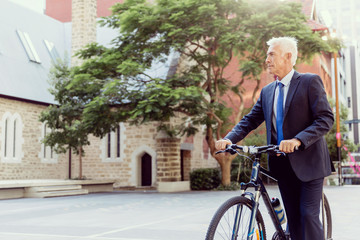 Obraz premium Successful businessman riding bicycle